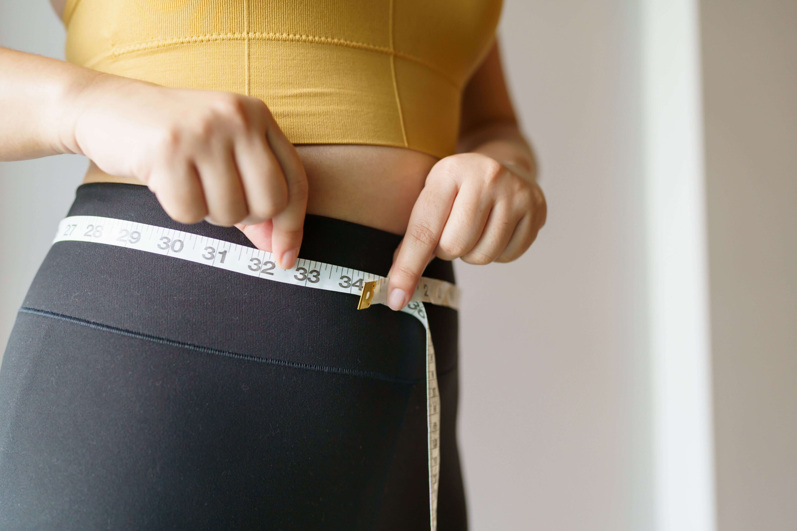 a person measuring her waist