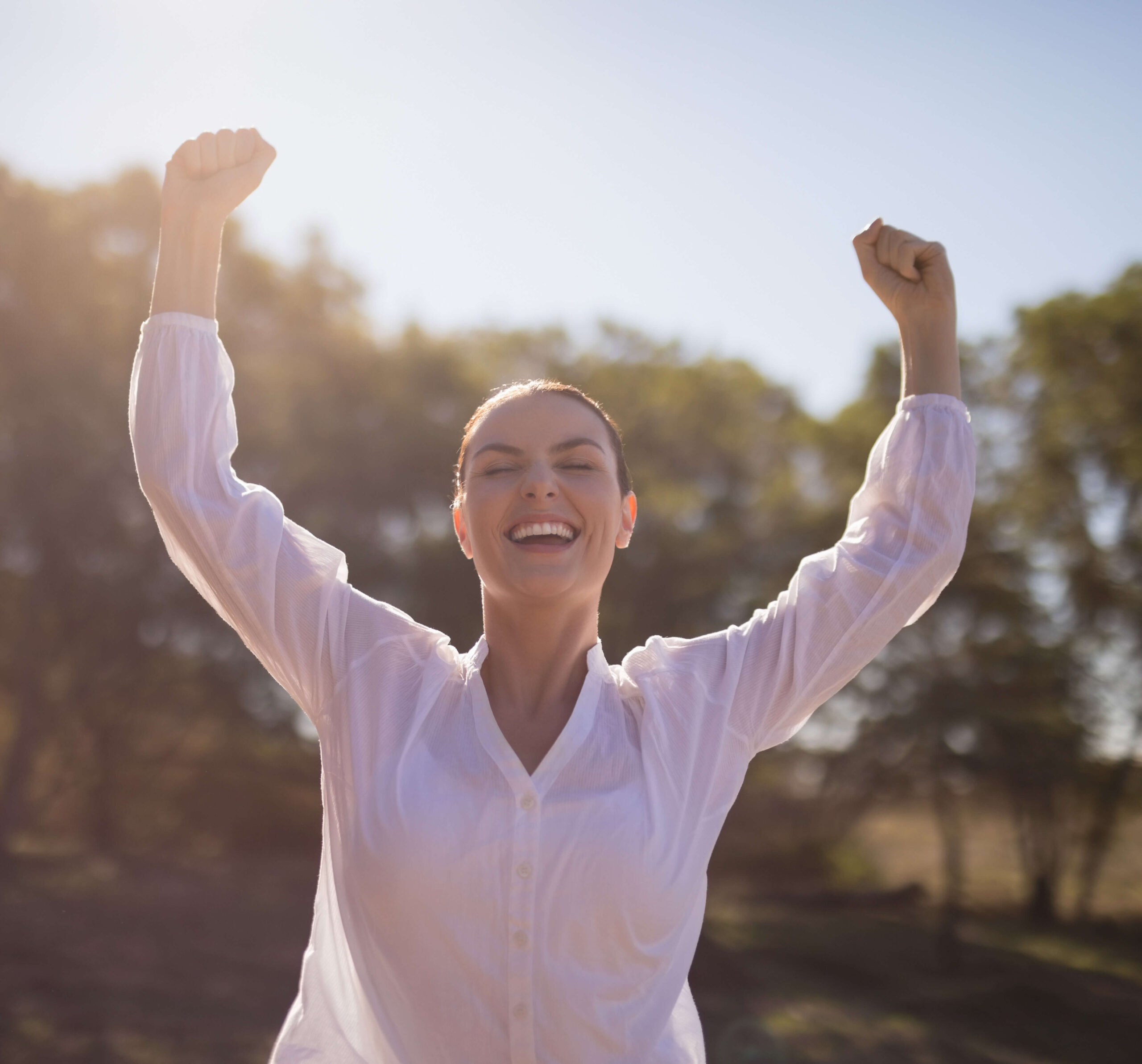 a woman with her arms raised in the air